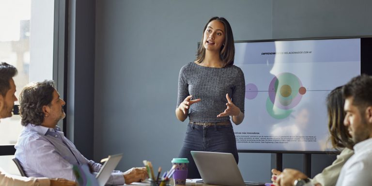 En kvinde giver en præsentation til en gruppe mennesker